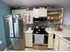 Well-lit kitchen featuring stainless steel appliances and tile flooring at 2516 Woodgate Blvd # 205, Orlando, FL 32822