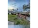 Scenery of the pond with a pedestrian bridge, community residences, and palm trees at 2516 Woodgate Blvd # 205, Orlando, FL 32822