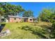 A brick home features a lush backyard with mature trees and green grass at 2640 Handley Blvd, Lakeland, FL 33803