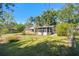 A lush backyard featuring green grass and mature trees surrounds this single Gathering home at 2640 Handley Blvd, Lakeland, FL 33803