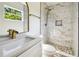 Modern bathroom showcasing a vanity with sink, a decorative mirror, and marble-look tiled shower at 2640 Handley Blvd, Lakeland, FL 33803