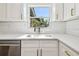 Close-up of kitchen sink with white cabinetry, quartz countertops, and stainless steel dishwasher at 2640 Handley Blvd, Lakeland, FL 33803