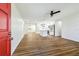 Open-concept living space featuring wood floors, a red front door, and a view into the kitchen at 2640 Handley Blvd, Lakeland, FL 33803