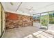 Enclosed sun room with tile floors, brick accent wall, and windows for natural light at 2640 Handley Blvd, Lakeland, FL 33803