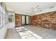 Enclosed sun room featuring tile floors, brick wall, and screened windows for ample light at 2640 Handley Blvd, Lakeland, FL 33803