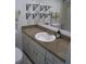 Bathroom featuring a vanity with a solid surface countertop, white cabinetry, and decorative shelves for storage and style at 266 Las Flores, Winter Haven, FL 33884