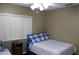 Neutral bedroom featuring a twin bed with blue plaid accents, complemented by a ceiling fan and natural light from the window at 266 Las Flores, Winter Haven, FL 33884