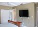 Bedroom with a wooden bed frame, closet doors, TV, and a glimpse into the en-suite bathroom at 266 Las Flores, Winter Haven, FL 33884