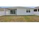 View of backyard with sliding glass doors and neutral-colored exterior at 287 Lake Smart Cir, Winter Haven, FL 33881