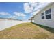 A fenced backyard with a bright blue sky and white clouds above creates a sunny and private outdoor space at 287 Lake Smart Cir, Winter Haven, FL 33881