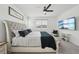 Comfortable bedroom with a tufted headboard, ceiling fan, and a wall-mounted television at 287 Lake Smart Cir, Winter Haven, FL 33881