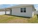 A home's exterior view showcases a sliding glass door, window, and compact yard, merging indoor comfort with outdoor accessibility at 287 Lake Smart Cir, Winter Haven, FL 33881