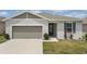 Charming single-story home features a 2-car garage, well-kept lawn, and stylish front door with decorative window at 287 Lake Smart Cir, Winter Haven, FL 33881