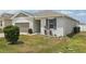Well-maintained single-story home with tidy lawn, simple landscaping, and 2-car garage at 287 Lake Smart Cir, Winter Haven, FL 33881