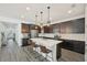 Well-lit kitchen featuring stainless steel appliances, dark cabinets, an island, and stylish pendant lighting at 287 Lake Smart Cir, Winter Haven, FL 33881