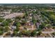 An aerial view shows the property among dense trees and buildings in this suburban neighborhood at 3022 Lantana Rd, Auburndale, FL 33823