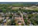 An aerial view displays the property, surrounded by lush greenery and ponds in the distance at 3022 Lantana Rd, Auburndale, FL 33823