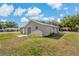 View of home from the backyard with a concrete patio and large grassy area at 3022 Lantana Rd, Auburndale, FL 33823