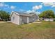 Backyard view of house with grassy area, a sliding door, and a small patio at 3022 Lantana Rd, Auburndale, FL 33823