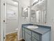 This bathroom offers a vanity with blue cabinets, ample lighting, and convenient access to amenities at 3022 Lantana Rd, Auburndale, FL 33823