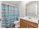 Bright bathroom features a single sink vanity, toilet and shower with a chevron curtain at 3022 Lantana Rd, Auburndale, FL 33823