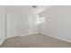 This bedroom features neutral carpet, a window and two entry doors at 3022 Lantana Rd, Auburndale, FL 33823