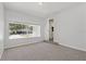 The cozy bedroom has neutral walls and carpet, and a bright window with a view at 3022 Lantana Rd, Auburndale, FL 33823