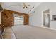Spacious living room featuring unique wooden walls, cozy carpet, ceiling fan, and sliding glass doors at 3022 Lantana Rd, Auburndale, FL 33823