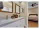 Bright bathroom featuring double sink vanity with granite countertops and wood framed mirrors at 3158 Beauchamp Ct, Winter Haven, FL 33884