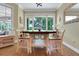 Bright breakfast nook features a wood table, modern chairs, and a large window with views of lush greenery at 3158 Beauchamp Ct, Winter Haven, FL 33884