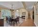 Elegant dining room with wood floors, decorative chandelier, arched doorways, and ample natural light at 3158 Beauchamp Ct, Winter Haven, FL 33884
