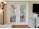 Bright room featuring french doors with views to the lanai, hardwood floors, and neutral paint at 3158 Beauchamp Ct, Winter Haven, FL 33884