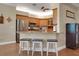 Bright kitchen featuring a breakfast bar, stainless steel appliances, wooden cabinets, and stylish stools at 3158 Beauchamp Ct, Winter Haven, FL 33884