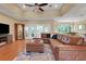 Cozy living room with hardwood floors, tray ceiling, leather sectional sofa, and access to outdoor spaces at 3158 Beauchamp Ct, Winter Haven, FL 33884