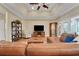 Comfortable living room features a large sectional sofa, tray ceiling, hardwood floors, and built-in shelving at 3158 Beauchamp Ct, Winter Haven, FL 33884