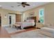 Bright main bedroom features a large bed, sliding barn door to the closet, and tranquil view at 3158 Beauchamp Ct, Winter Haven, FL 33884