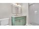 Bright bathroom featuring a stylish green vanity, white counters, and tiled walk-in shower at 333 Lake Otis Se Dr, Winter Haven, FL 33880