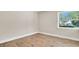 Cozy bedroom features laminate flooring, neutral walls, and a bright window overlooking the outdoors at 333 Lake Otis Se Dr, Winter Haven, FL 33880