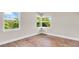 Empty bedroom featuring hardwood floors and natural light from the corner double windows at 333 Lake Otis Se Dr, Winter Haven, FL 33880