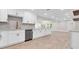Kitchen featuring an island, stainless steel appliances, hardwood floors, and white cabinetry at 333 Lake Otis Se Dr, Winter Haven, FL 33880