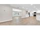 Open living space with laminate flooring and white cabinets, offering a seamless transition to the kitchen at 333 Lake Otis Se Dr, Winter Haven, FL 33880