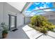 Tranquil covered courtyard with lush landscaping and a view of the blue sky at 3374 Waterlute Way, Lakeland, FL 33811