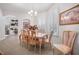 Bright dining room with white walls, shuttered windows, neutral tile flooring, a chandelier, and seating for six at 3374 Waterlute Way, Lakeland, FL 33811