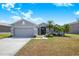 Charming gray home featuring a two-car garage, well-kept lawn, and lush tropical landscaping in a desirable neighborhood at 3374 Waterlute Way, Lakeland, FL 33811
