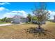 A well-maintained gray home features tropical landscaping, a green lawn, and a tranquil atmosphere at 3374 Waterlute Way, Lakeland, FL 33811