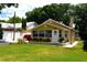 Inviting bungalow features a welcoming front porch, well-manicured lawn, and lush, colorful flower beds at 418 E 10Th Ave, Mount Dora, FL 32757