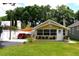 Charming bungalow featuring a covered parking area, a white picket fence, and well-maintained landscaping at 418 E 10Th Ave, Mount Dora, FL 32757