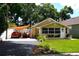 Bungalow featuring a covered parking area, a well-maintained lawn, and lush landscaping at 418 E 10Th Ave, Mount Dora, FL 32757