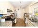 Functional galley kitchen with stone countertops, stainless steel appliances, and ample storage space at 418 E 10Th Ave, Mount Dora, FL 32757
