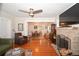 Spacious living room with hardwood floors, fireplace, and open access to the dining area at 418 E 10Th Ave, Mount Dora, FL 32757